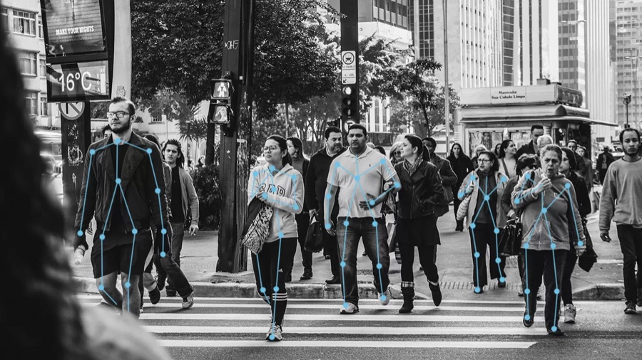 Human-pose keypoint skeletons mapped across a crowd at a crosswalk
